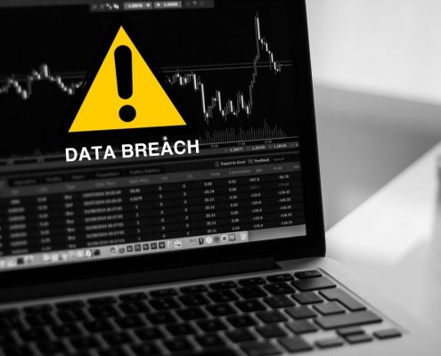 Data breach on laptop with warning sign